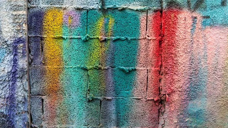 A cinderblock wall painted in numerous colors